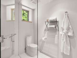 Experience modern comfort in this pristine bathroom, featuring a sleek glass-enclosed shower and a contemporary toilet.