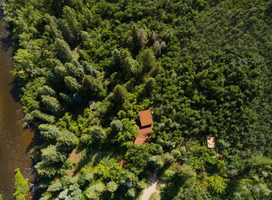 Nestled amidst a lush forest, this property offers a serene retreat with a charming cabin and a winding river.