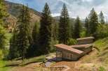 Nestled amidst a lush forest and rolling hills, this modern home offers a serene retreat.
