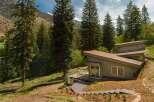 Nestled amidst towering evergreen trees and rolling hills, this modern home offers a serene mountain retreat.