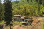 Nestled amidst a lush green hillside, this modern home offers a serene retreat with stunning natural surroundings.
