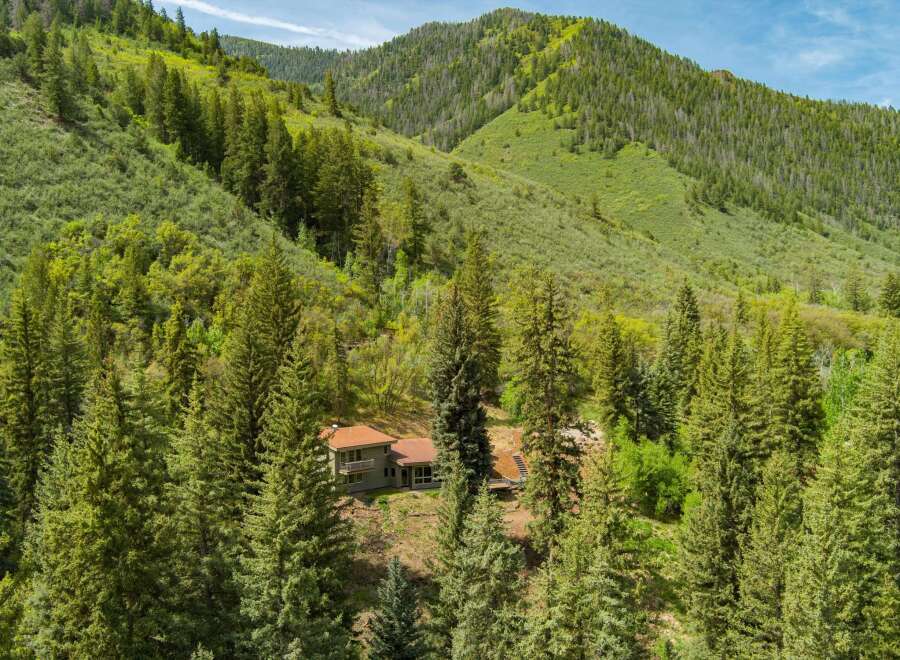 Nestled amidst a lush forest, this secluded home offers a tranquil retreat with stunning mountain views.
