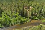 Nestled amidst a lush forest, this property offers a serene escape with a charming house overlooking a tranquil river.