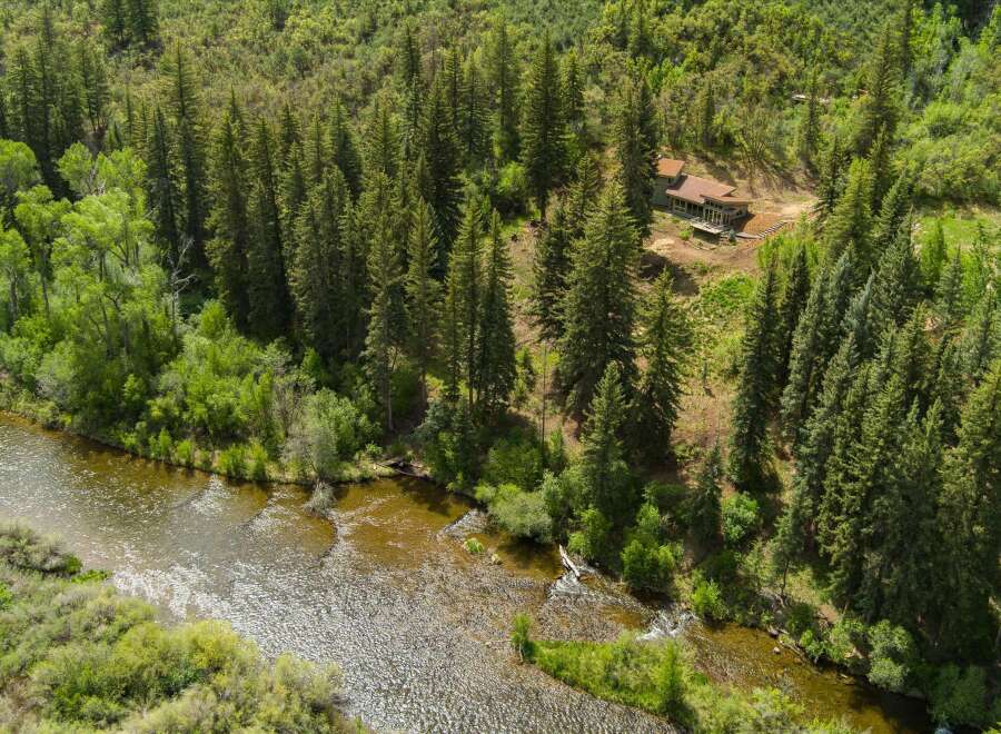 Nestled amidst a lush pine forest, this stunning property offers a serene retreat with a modern home overlooking a tranquil river.