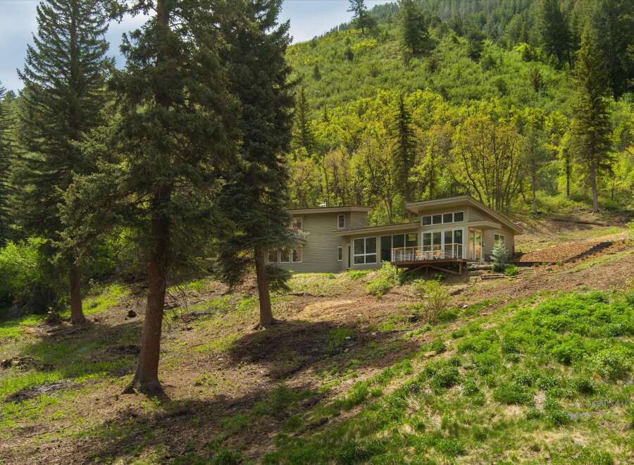 Nestled amidst a lush forest, this modern home offers stunning natural views and a serene living experience.
