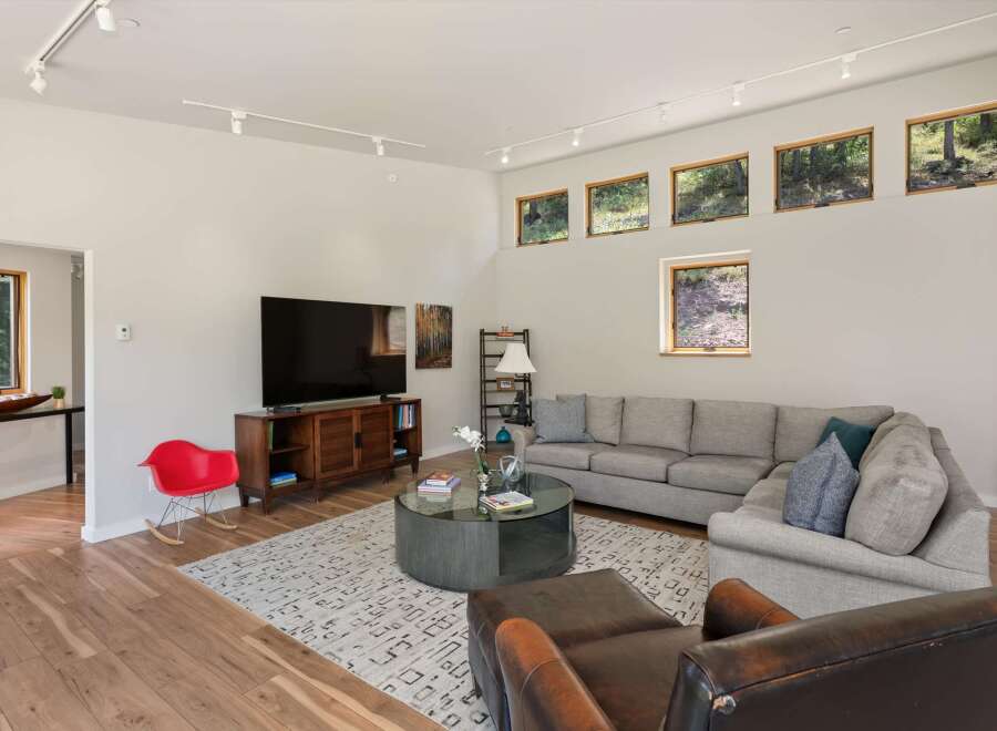 Experience modern living in this spacious living room featuring a large sectional sofa, a stylish coffee table, and a sleek entertainment center.