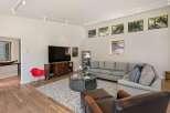 Experience modern living in this spacious living room featuring a large sectional sofa, a stylish coffee table, and a sleek entertainment center.
