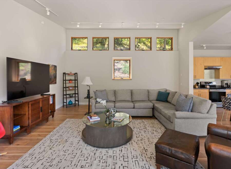 This spacious living room features a large sectional sofa, a modern coffee table, and a sleek entertainment center with a flat-screen TV.