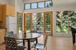 Experience breathtaking mountain views from this stunning dining area, featuring a round wooden table and chairs with a unique patterned upholstery.