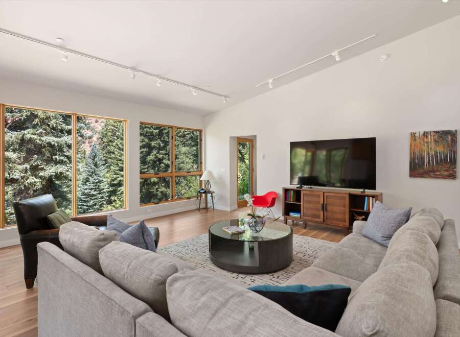 Experience modern living in this spacious great room, featuring a large sectional sofa and a stylish media console.