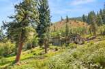 Nestled amidst a lush hillside, this modern home offers breathtaking views and a serene escape.