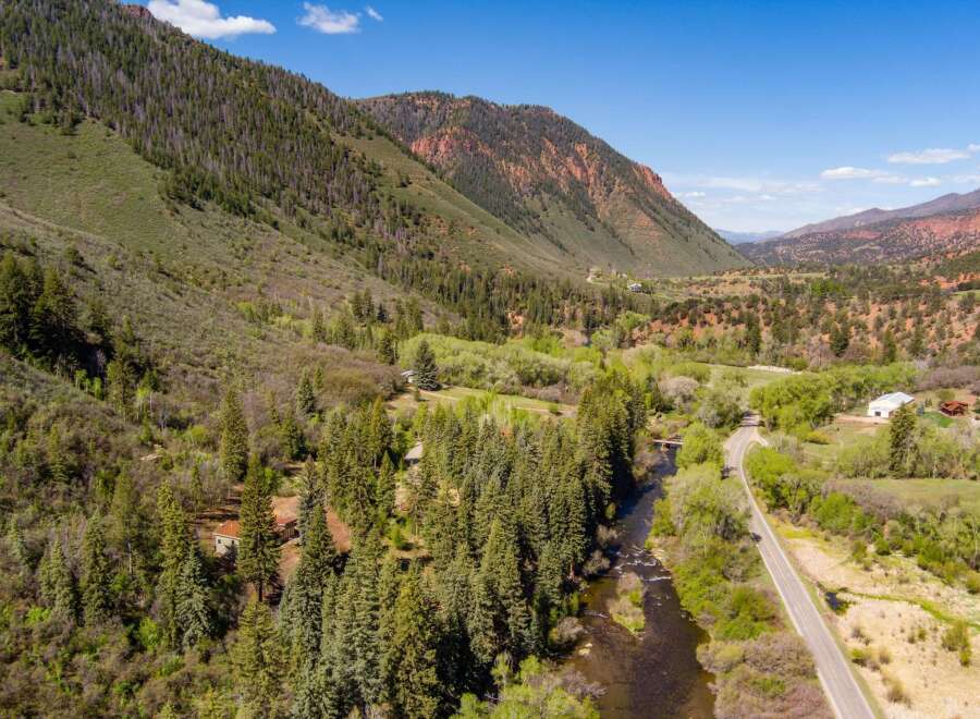 Nestled in a picturesque mountain valley, this property offers a serene retreat with a winding river and lush greenery.