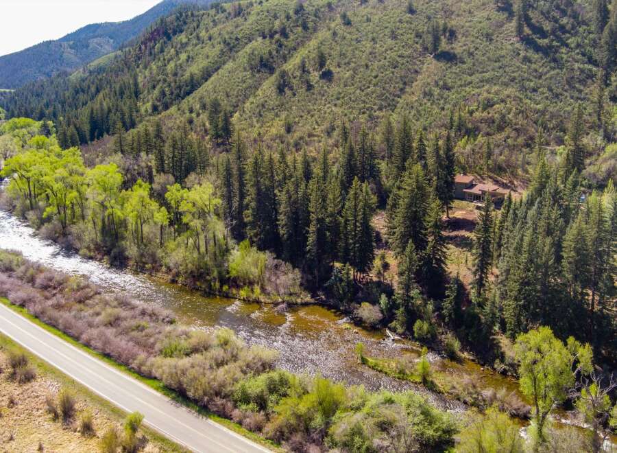 Experience the ultimate mountain lifestyle with this stunning property nestled alongside a pristine river and surrounded by lush evergreen forests.