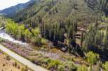 Experience the ultimate mountain lifestyle with this stunning property nestled alongside a pristine river and surrounded by lush evergreen forests.