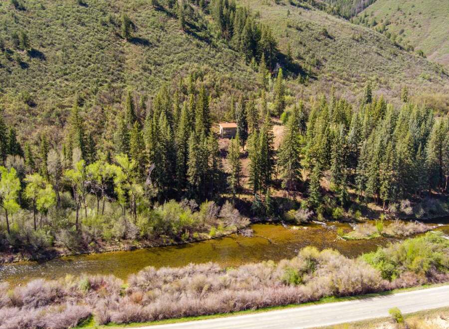 Escape to this secluded mountain retreat, nestled amongst towering pine trees and overlooking a serene river.