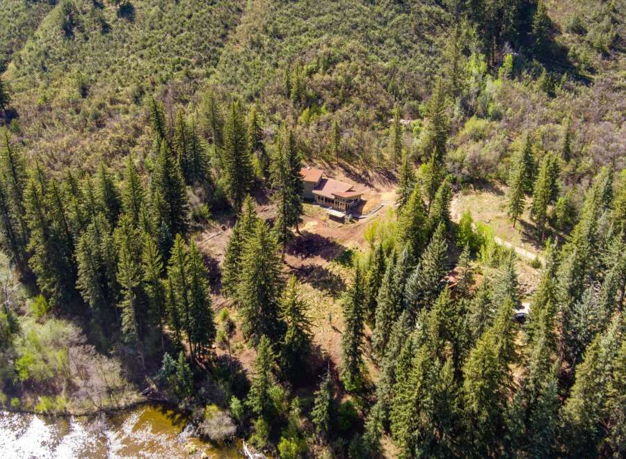 Nestled amidst a lush forest, this property offers a serene retreat with a charming home featuring a spacious deck perfect for enjoying the natural surroundings.