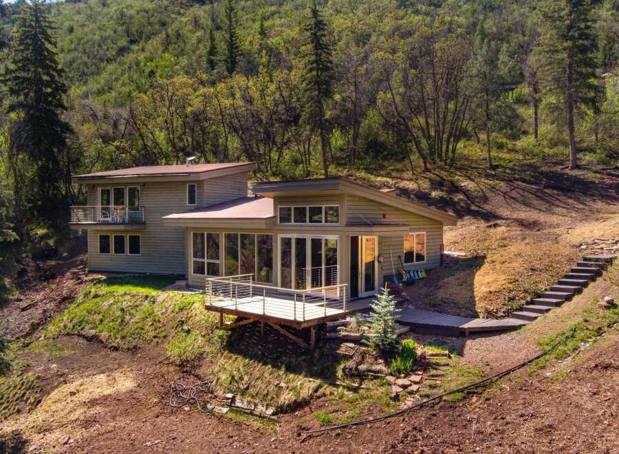 Nestled amidst lush greenery, this contemporary home offers a serene retreat with stunning natural views.