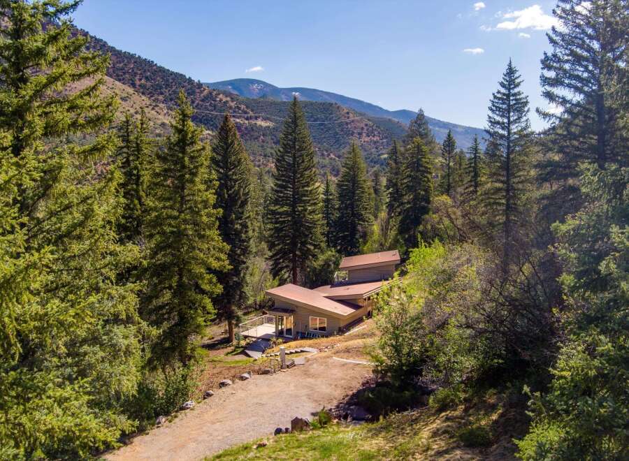 Nestled amidst a serene forest landscape, this unique home offers a tranquil retreat with stunning mountain views.