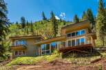 Experience modern living nestled in nature with this stunning home featuring expansive windows that bring the outdoors in.