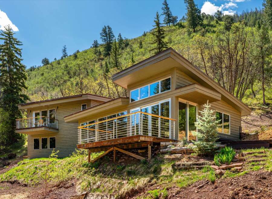 Nestled on a lush hillside, this modern home offers stunning natural views and a seamless indoor-outdoor living experience.