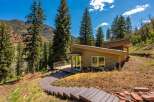 Nestled amidst towering pine trees and a scenic mountain backdrop, this modern home offers a unique architectural design.