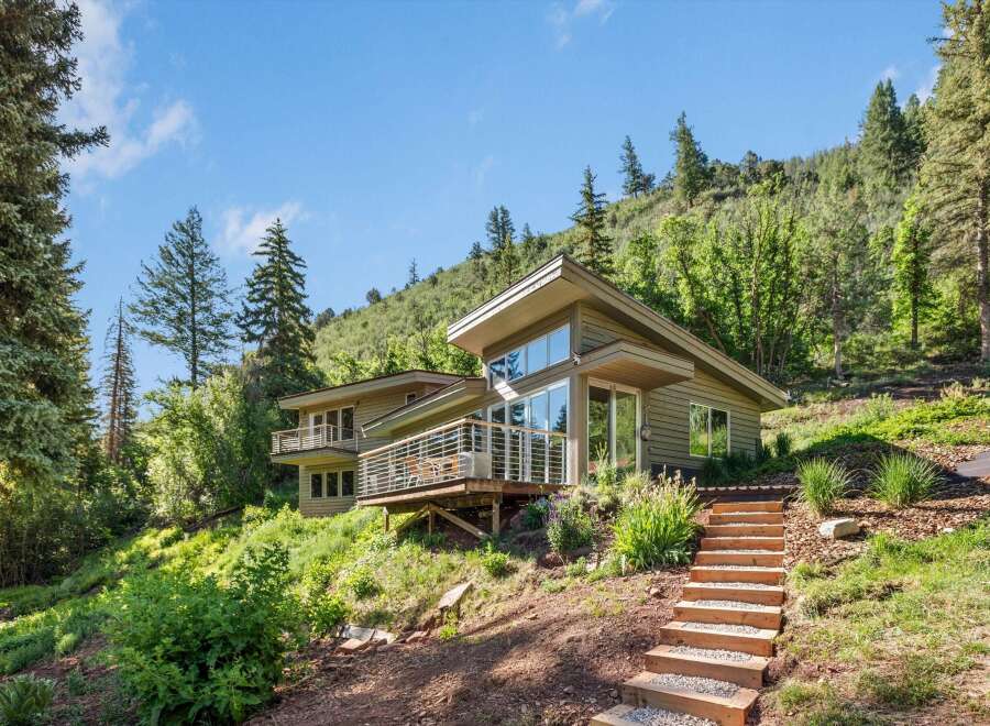 Nestled amidst lush greenery and rolling hills, this modern home offers a serene retreat with stunning natural views.