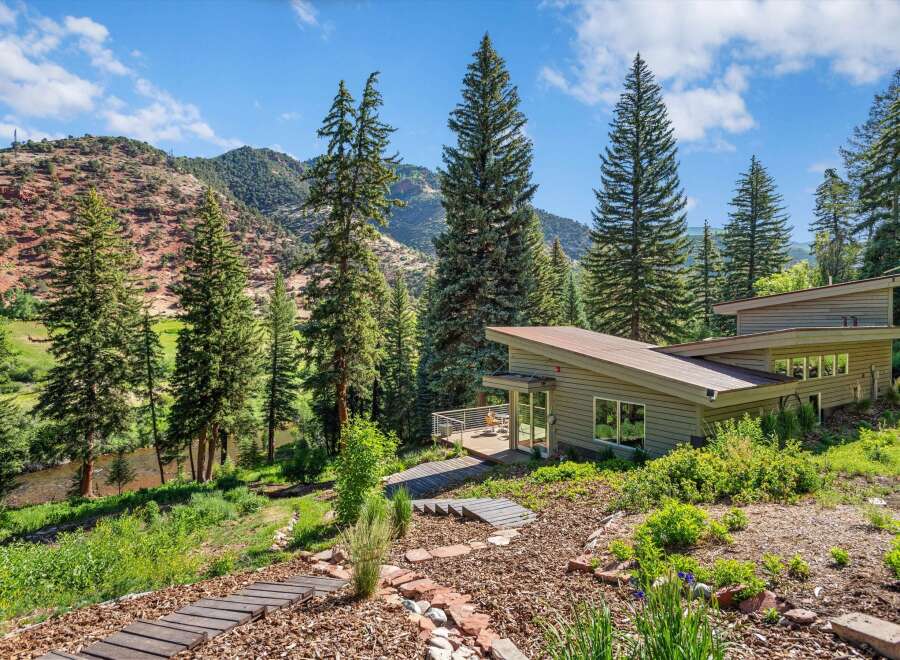 Nestled amidst towering pine trees and a serene river, this modern architectural gem offers a unique living experience.