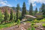 Nestled amidst towering pine trees and a serene river, this modern architectural gem offers a unique living experience.