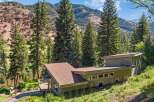 Nestled amidst towering evergreen trees and rolling hills, this modern home offers a serene retreat.