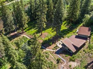 Nestled amidst a lush pine forest, this property offers a serene retreat with a charming home featuring a spacious deck perfect for enjoying the natural surroundings.