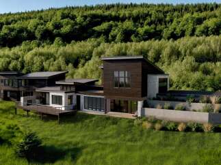 Experience modern luxury in this stunning hillside residence, featuring a striking dark wood facade and expansive glass windows that seamlessly blend indoor and outdoor living.