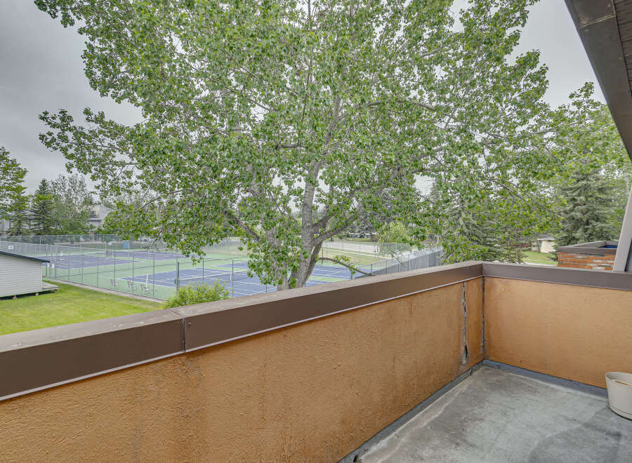 Enjoy stunning views of the tennis courts and lush greenery from this private balcony.