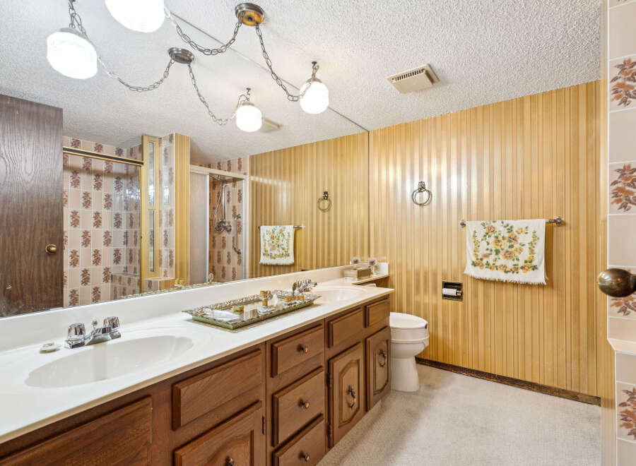 Step into this charming bathroom featuring a spacious vanity with a double sink and ample storage.
