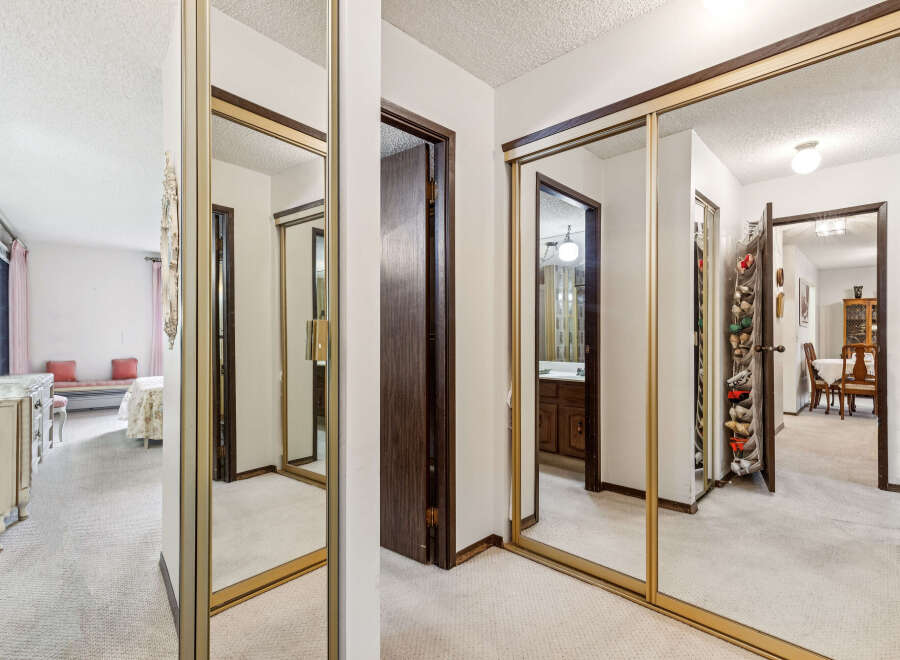 Step into a well-lit hallway featuring expansive mirrored closet doors that enhance the sense of space.