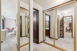 Step into a well-lit hallway featuring expansive mirrored closet doors that enhance the sense of space.