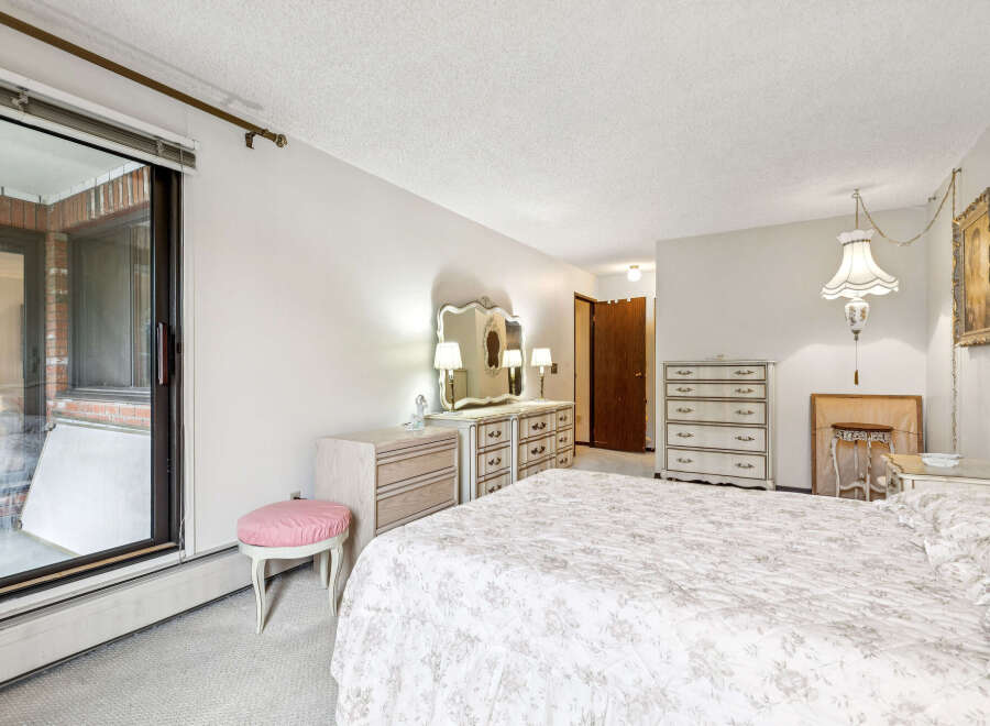 Step into this charming bedroom featuring a large sliding glass door that opens to a private patio, perfect for enjoying fresh air.