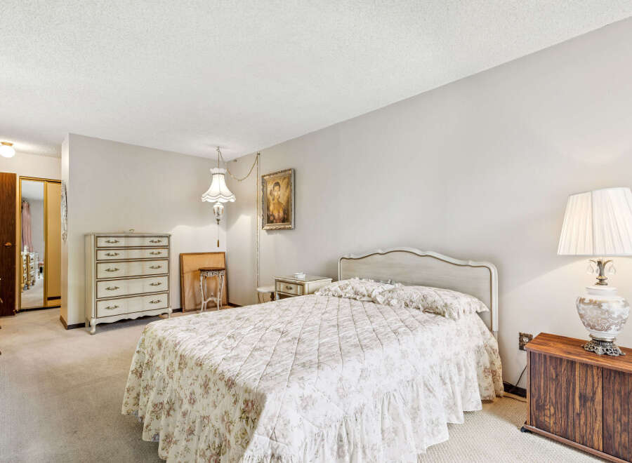 Step into this charming bedroom, featuring a cozy bed adorned with a floral comforter and matching pillows.