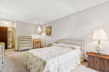 Step into this charming bedroom, featuring a cozy bed adorned with a floral comforter and matching pillows.
