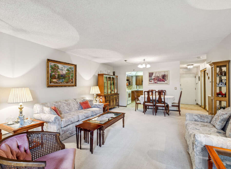 Step into this charming living and dining area, featuring a comfortable floral-patterned sofa and a cozy armchair perfect for relaxation.