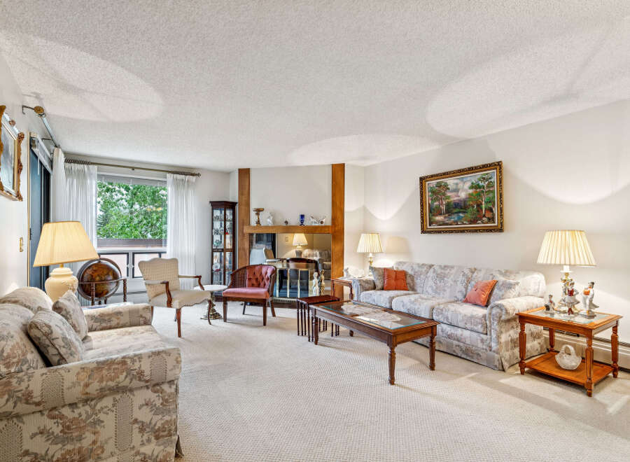 Step into this inviting living room, featuring a floral-patterned sofa and a matching loveseat, perfect for cozy gatherings.