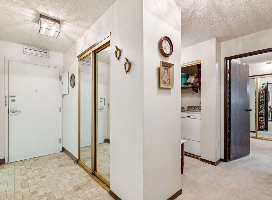 Step into this welcoming entryway featuring a bright white door with modern hardware and a convenient built-in ventilation system.