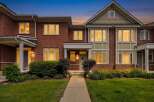 This stunning brick townhouse offers a welcoming entrance with a covered porch and well-maintained landscaping.