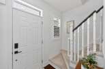 Step into this welcoming entryway featuring a bright white front door with a modern black lockset.