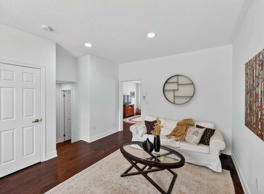 Step into this inviting living space featuring a comfortable white sofa adorned with decorative pillows and a cozy throw.