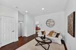 Step into this inviting living space featuring a comfortable white sofa adorned with decorative pillows and a cozy throw.