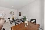 This inviting dining area features a rustic wooden table with dark wood chairs, perfect for family gatherings.
