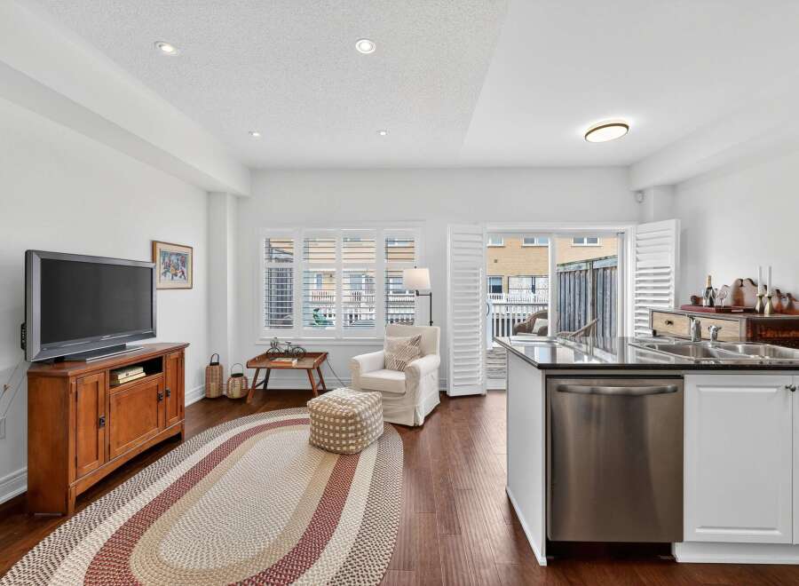 This open-concept living and kitchen area features a cozy seating arrangement with a plush armchair and ottoman, perfect for relaxing.