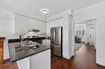 Step into this beautifully updated kitchen, featuring sleek white cabinetry and a modern granite countertop with a double sink.