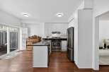 Discover this bright and airy kitchen featuring sleek white cabinetry and a spacious island with a granite countertop.