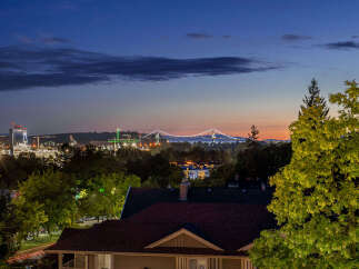Experience breathtaking twilight views from this stunning property, showcasing a majestic illuminated bridge and a vibrant cityscape.